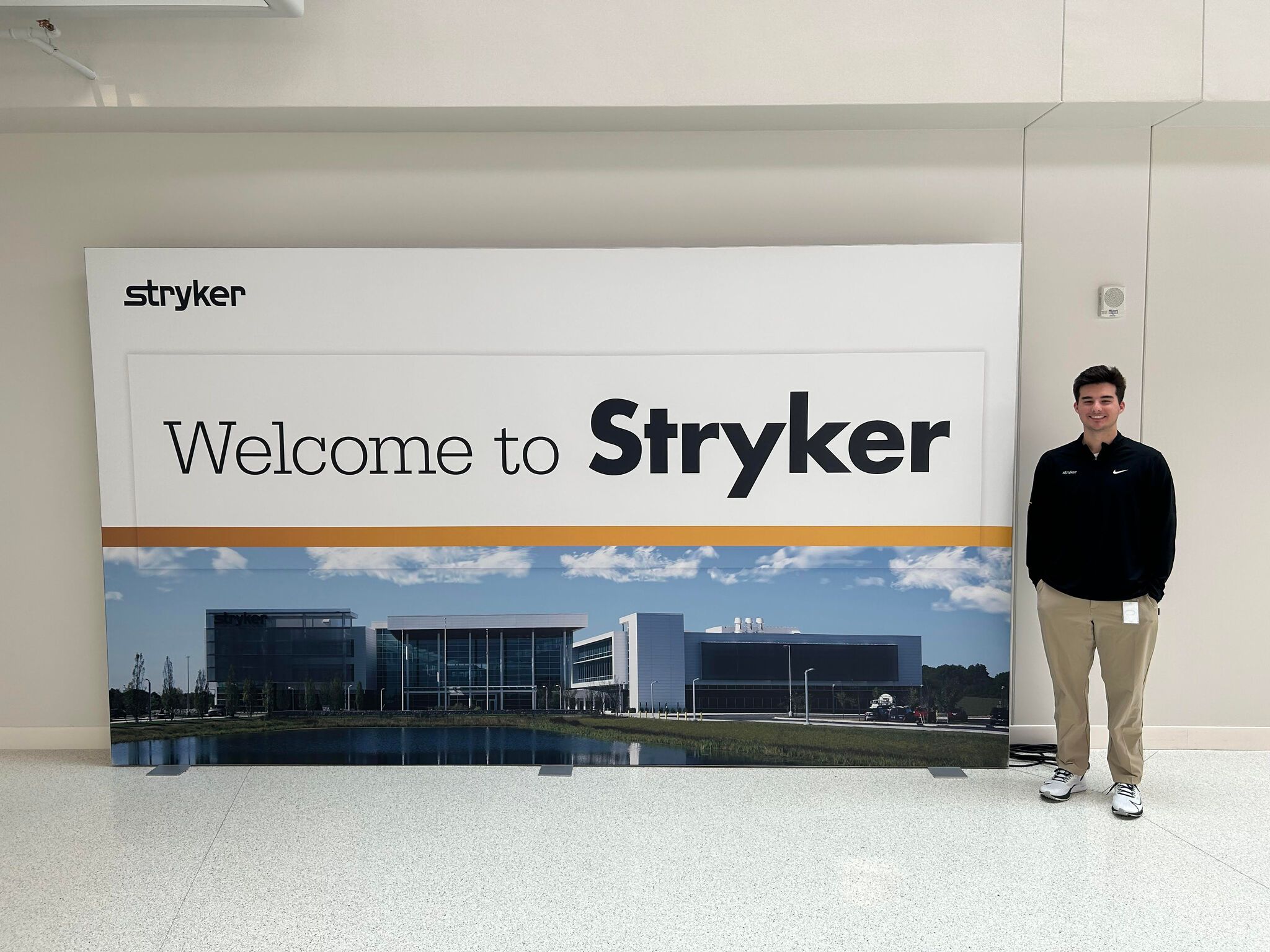 A student standing beside a Welcome to Stryker banner